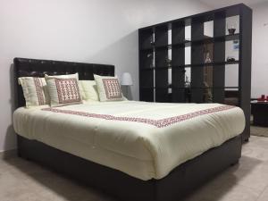 a large bed with a black headboard in a room at Tunaib Plaza in Aţ Ţunayb