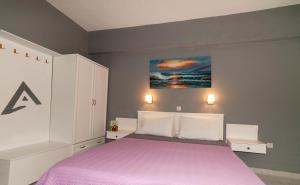 a bedroom with a bed with a purple blanket at Alpha Studios in Arkasa