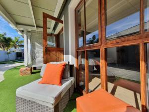a screened in porch with an orange pillow on a house at Two Fat Owls Guesthouse in George