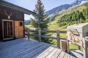 a porch of a cabin with a rv on a deck at Chalet Büdemji by Arosa Holiday in Arosa