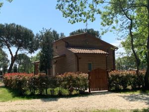 une maison avec un portail en face d'une cour dans l'établissement Casina Miriano, à Castiglione del Lago