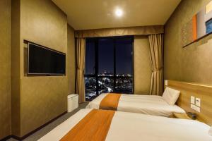 a hotel room with two beds and a large window at Dormy Inn SEOUL Gangnam in Seoul