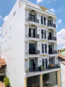 邦美蜀Huyen Nga Hotel的一栋白色建筑，侧面有阳台
