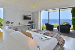 a bedroom with a large bed with a view of the ocean at Dream Villa Petit Cul de Sac 720 in Saint Barthelemy