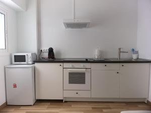 a white kitchen with a sink and a microwave at Lanzalina in Arrecife