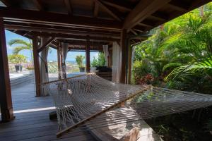 a hammock on the porch of a house at Dream Villa Marigot 771 in Saint Barthelemy
