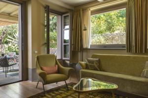a living room with a couch and chairs and windows at Locanda al Colle in Camaiore