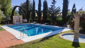 a swimming pool in a yard with trees at Hotel Rural Puerto Mágina in Torres