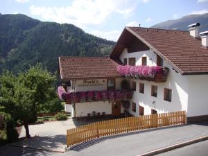 un edificio con flores a un lado. en Machls Ferienwohnungen, en Jerzens