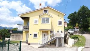 una casa amarilla con escaleras delante en Apartments Turan en Rijeka
