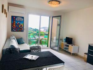 a living room with a couch and a table with chairs at Appartement Sous le Soleil vue mer, parking inclus , clim ,wifi in Collioure