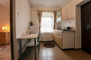 a small kitchen with a table and a refrigerator at Gloria Apartments in Sighişoara