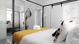 um quarto com uma cama e um espelho em Bondi Surf Cottage em Sydney