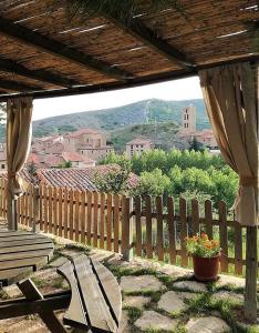 a patio with a bench and a wooden fence at Casa Elpatiodelmaestrazgo in Villarroya de los Pinares