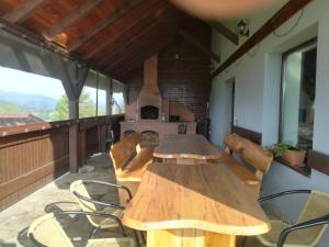 a wooden table and chairs on a balcony with a stove at Casa Maria in Piatra Fantanele +36 photos