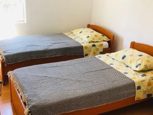two twin beds in a room withthritisthritisthritisthritisthritisthritisthritisthritisthritis at Apartmani Lovre Posedarje in Posedarje