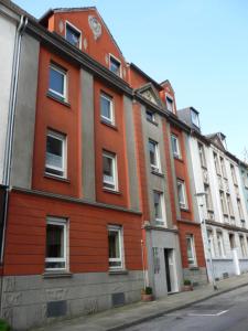 un bâtiment rouge sur le côté d'une rue dans l'établissement feelathome, à Essen