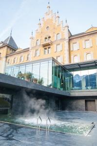 a building with a pool of water in front of a building at Grand Hotel Billia in Saint Vincent