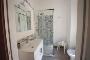 een witte badkamer met een wastafel en een douche bij B&B Porta di Ponte in Agrigento