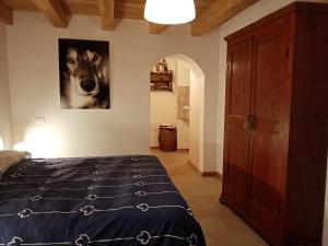 a bedroom with a bed and a picture of a dog at Agriturismo Athabaska in San Lorenzo in Banale