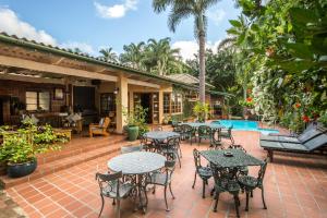 an outdoor patio with tables and chairs next to a pool at Wendy's Country Lodge in Mtubatuba