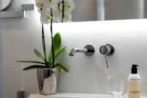 a vase with a plant on a counter with a mirror at Bed en Breakfast de Olm in Kaatsheuvel