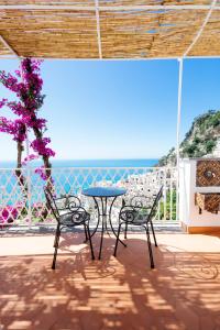 un patio con una mesa y dos sillas y el océano en La Bizantina Luxury Villa, en Positano