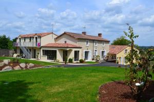 una gran casa blanca con patio en Gîtes de la Bibudière en Le Boupère