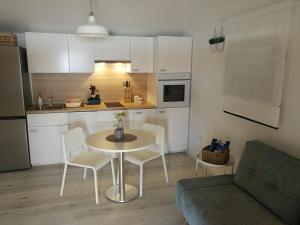 una piccola cucina con tavolo, sedie e divano di Apartmani Sandra i Davor Lonic a Kukljica (Cuclizza)