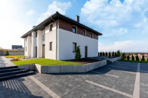 Biały dom z brązowym dachem w obiekcie Amare Apartments A2 w mieście Mosty