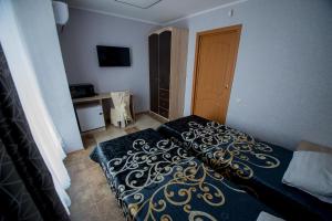 a bedroom with a bed with a black and gold blanket at Hotel Zolotoi Lev in Omsk