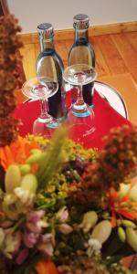 a table with two wine glasses and a plate of vegetables at Privathotel Der Schwarze Herrgott No TV in Zellertal