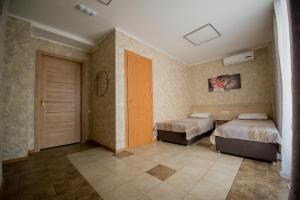 a bedroom with two beds and a door in it at Hotel Zolotoi Lev in Omsk
