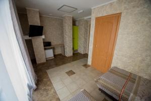 a room with a door and a couch and a television at Hotel Zolotoi Lev in Omsk