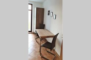 een eetkamer met een houten tafel en zwarte stoelen bij enjoy Leipzig FeWo Leipzig-Schönefeld in Leipzig +4 foto's