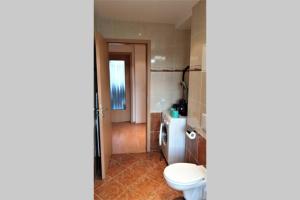 een badkamer met een wit toilet en een wastafel bij enjoy Leipzig FeWo Leipzig-Schönefeld in Leipzig