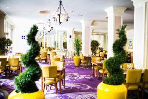 a restaurant with yellow chairs and tables and chairs at The Angel Hotel in Cardiff