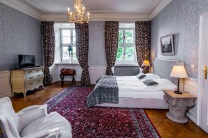 a bedroom with a large bed and a chandelier at Hotel Palac Staniszow in Jelenia Góra