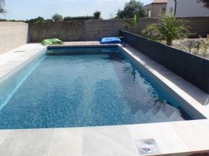 una piscina con agua azul en un patio trasero en La Belgerie en La Bernerie-en-Retz