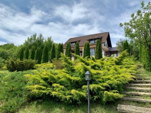 a house surrounded by green trees and bushes at Hidden Hills Villa in Ţipăreşti