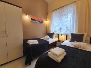 a room with two beds with towels on them at DWIE SOSNY Apartamenty przy plaży - 365PAM in Ustronie Morskie