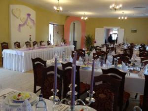 a banquet room with tables with white tablecloths at Kaštieľ Biela Dáma a Čierny Rytier in Krompachy