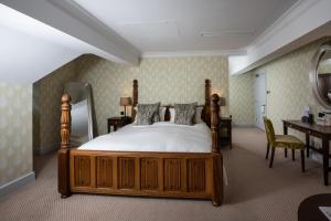 a bedroom with a bed and a desk and a mirror at The Wood Norton in Evesham