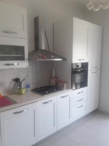 La cuisine est équipée de placards blancs et d'un four avec plaques de cuisson. dans l'établissement Casa Vacanze Clementina, à Paduli