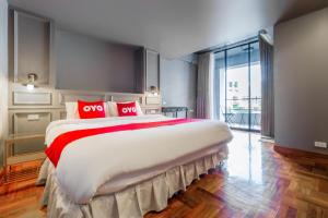 a large bedroom with a large bed with red pillows at OYO 1042 Boon’s Residence (Sathorn) in Bangkok