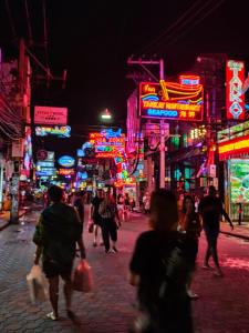 a crowd of people walking down a street at night at The Encore Hotel in Pattaya South