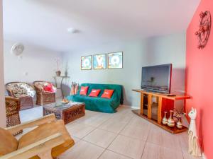 a living room with a green couch and a tv at OYO Pousada Recanto Shangrilá, Cabo Frio in Cabo Frio