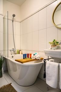 Baño blanco con bañera y lavamanos en Villa Louis en Ventspils