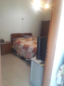 a bedroom with a bed and a desk with a television at Casa Vacanze Messano in Paduli +5 photos