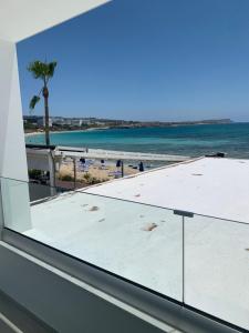 a view of the beach from the window of a building at Karousos Beach Rooms in Ayia Napa